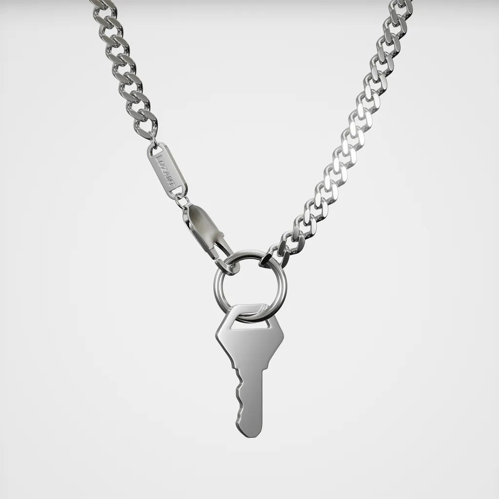 Silver key necklace on a light gray background close up