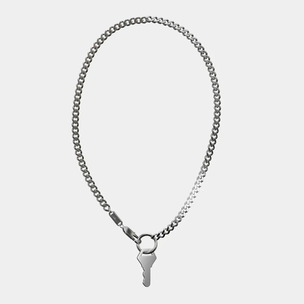 Silver chain necklace with a key pendant full view top down