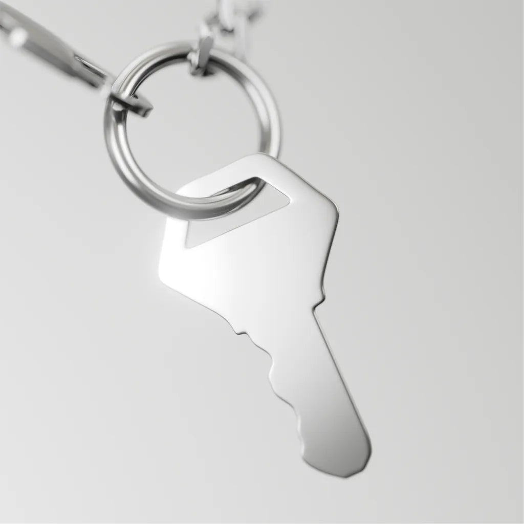 Silver keychain with a unique design on a light gray background